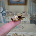 Load image into Gallery viewer, Miniature model of a coffee cup and pastry on a wooden tray held between fingers with a blurred background.
