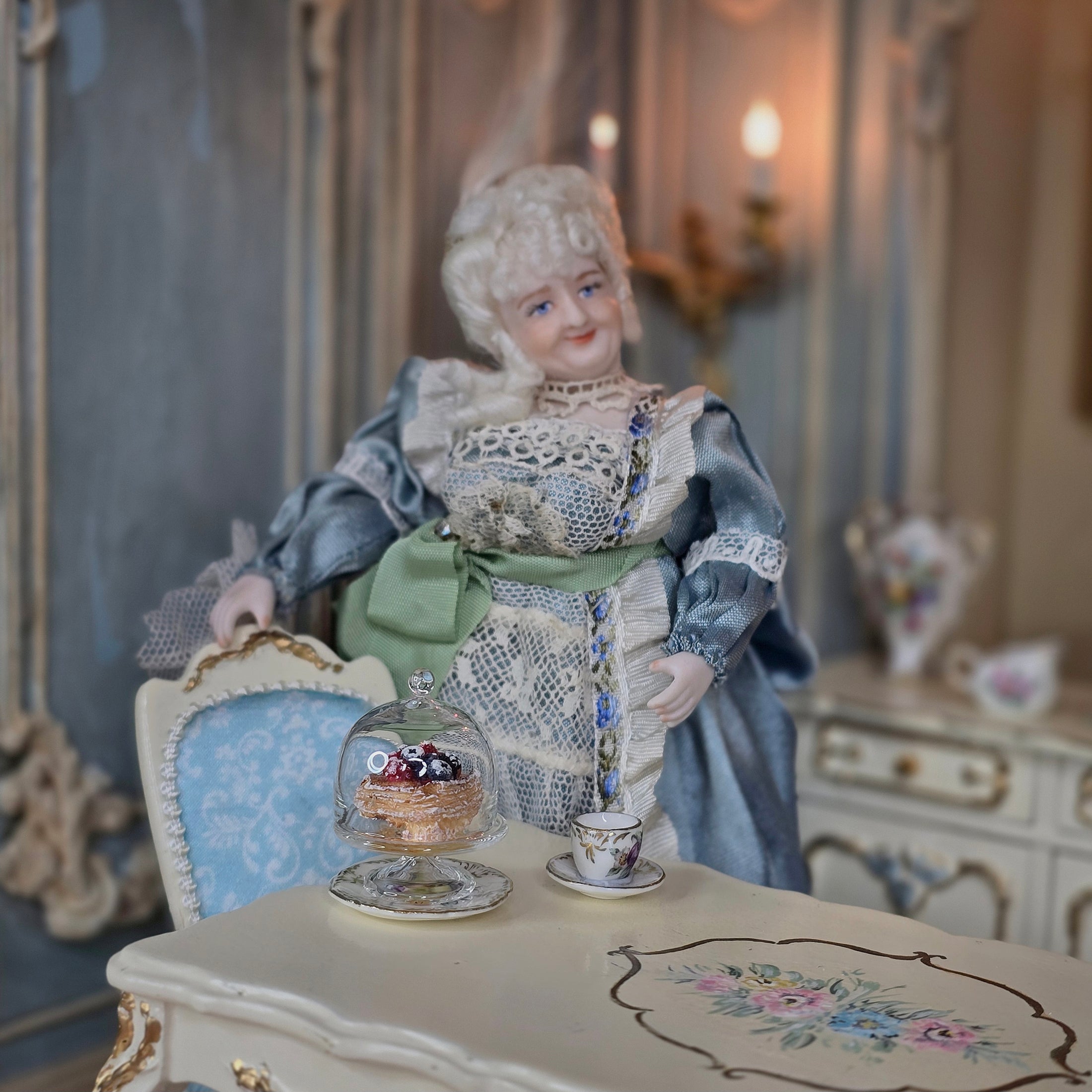 Vintage-style doll in a decorative setting with a table and ornate background