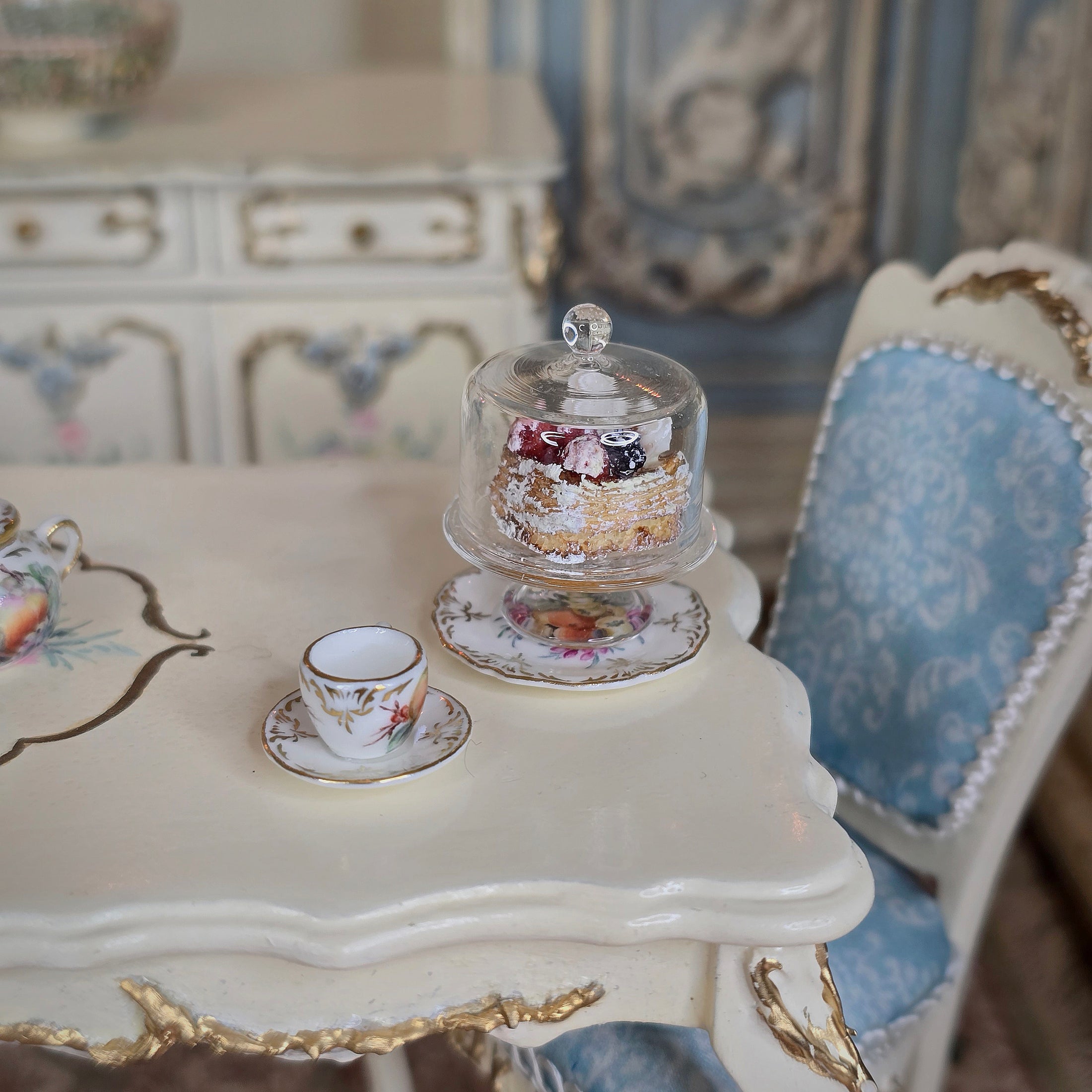 miniature pastry under a dome in an elegant room.