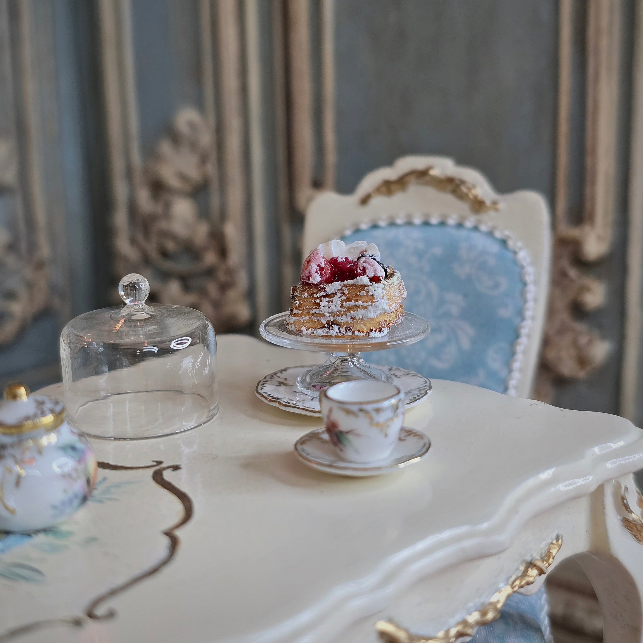 pastry on cake stand on a decorative table in an elegant room.