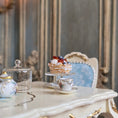 Load image into Gallery viewer, Tea set with a pastry on a table in a elegant room.
