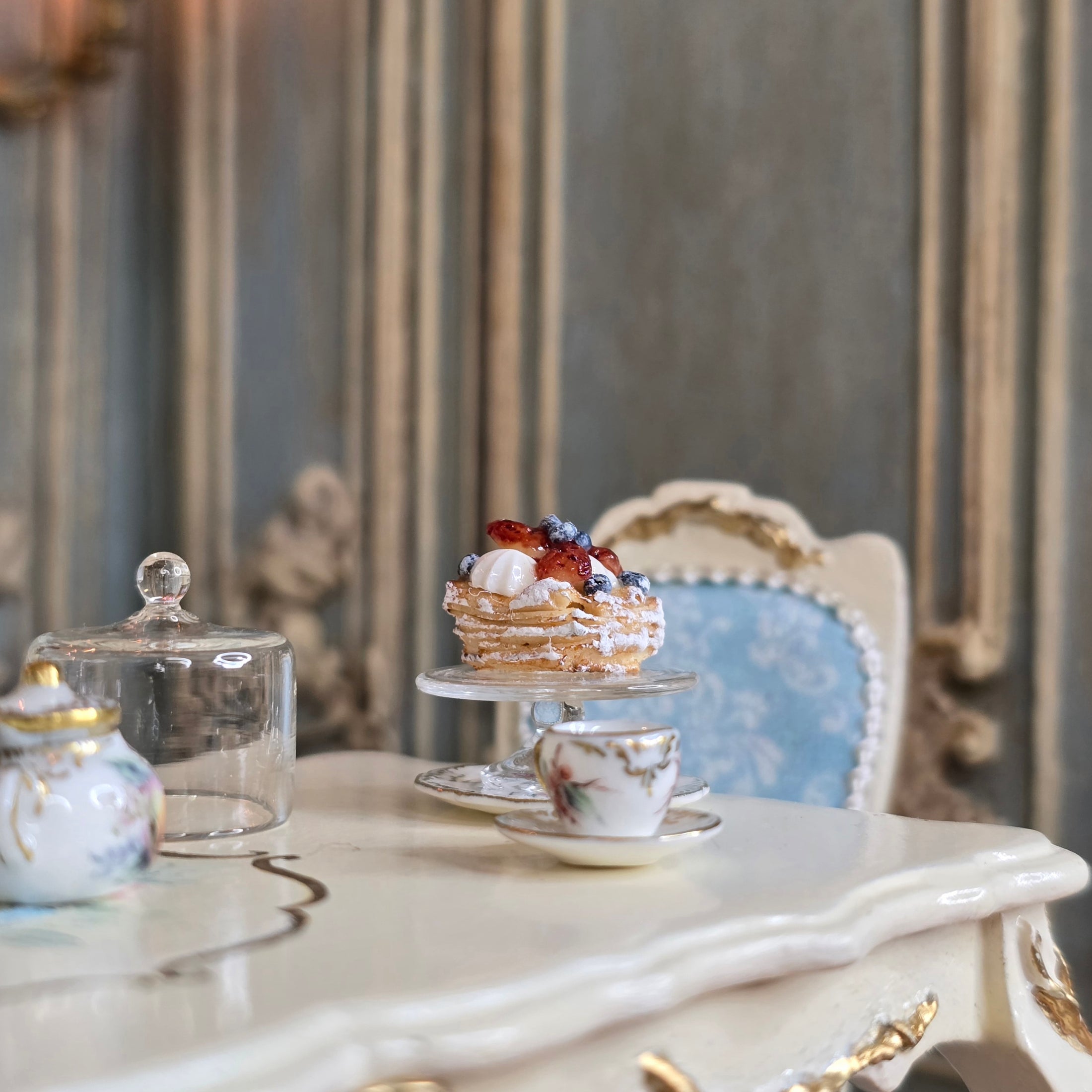 Tea set with a pastry on a table in a elegant room.