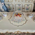 Load image into Gallery viewer, Miniature dessert under a clear dome on an ornate table with decorative background
