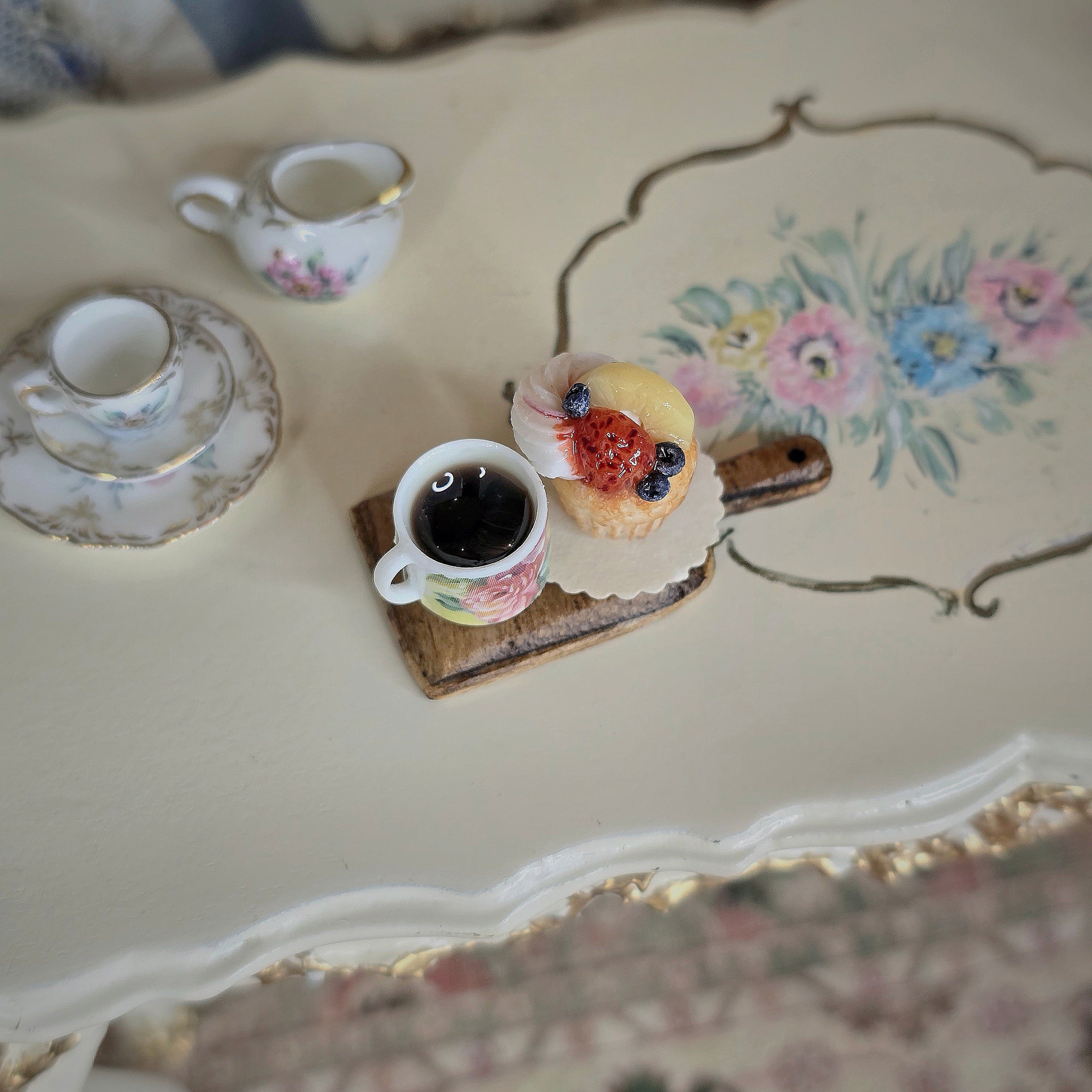 Tea cup and cupcake on a decorative table.