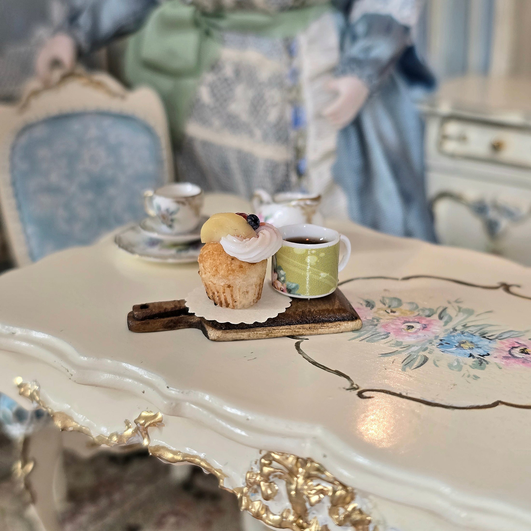 Tea cup and cupcake on a decorative table with a blurred background