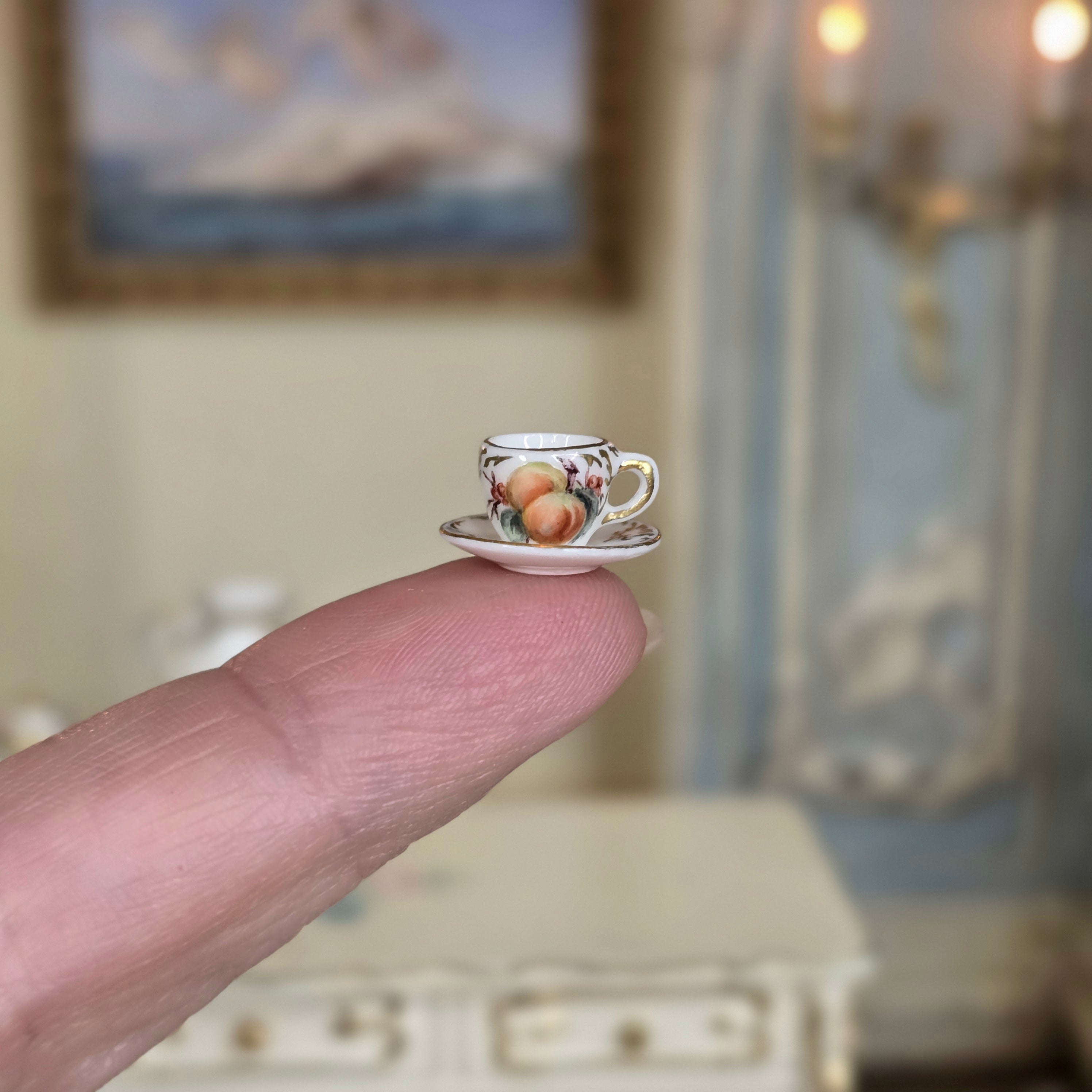 Hand painted Miyuki Nagashima porcelain teacup and saucer on finger