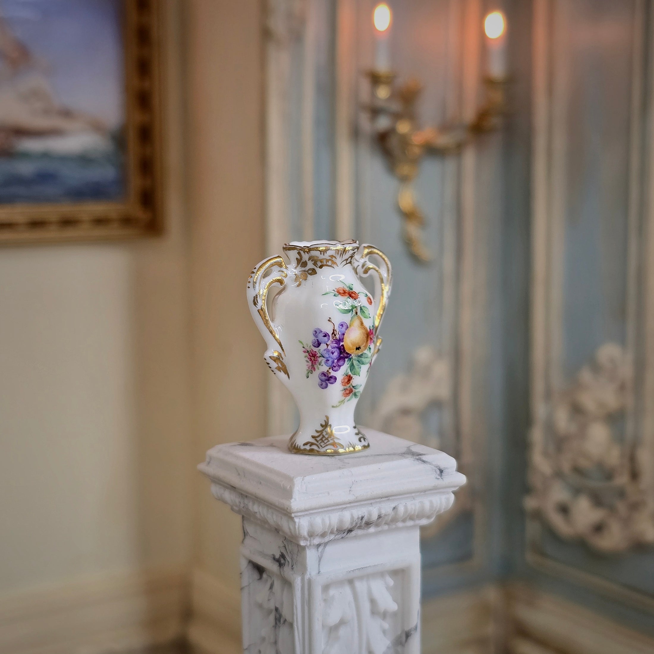 Decorative vase on a pedestal in an elegant room with a painting and candlestick in the background.