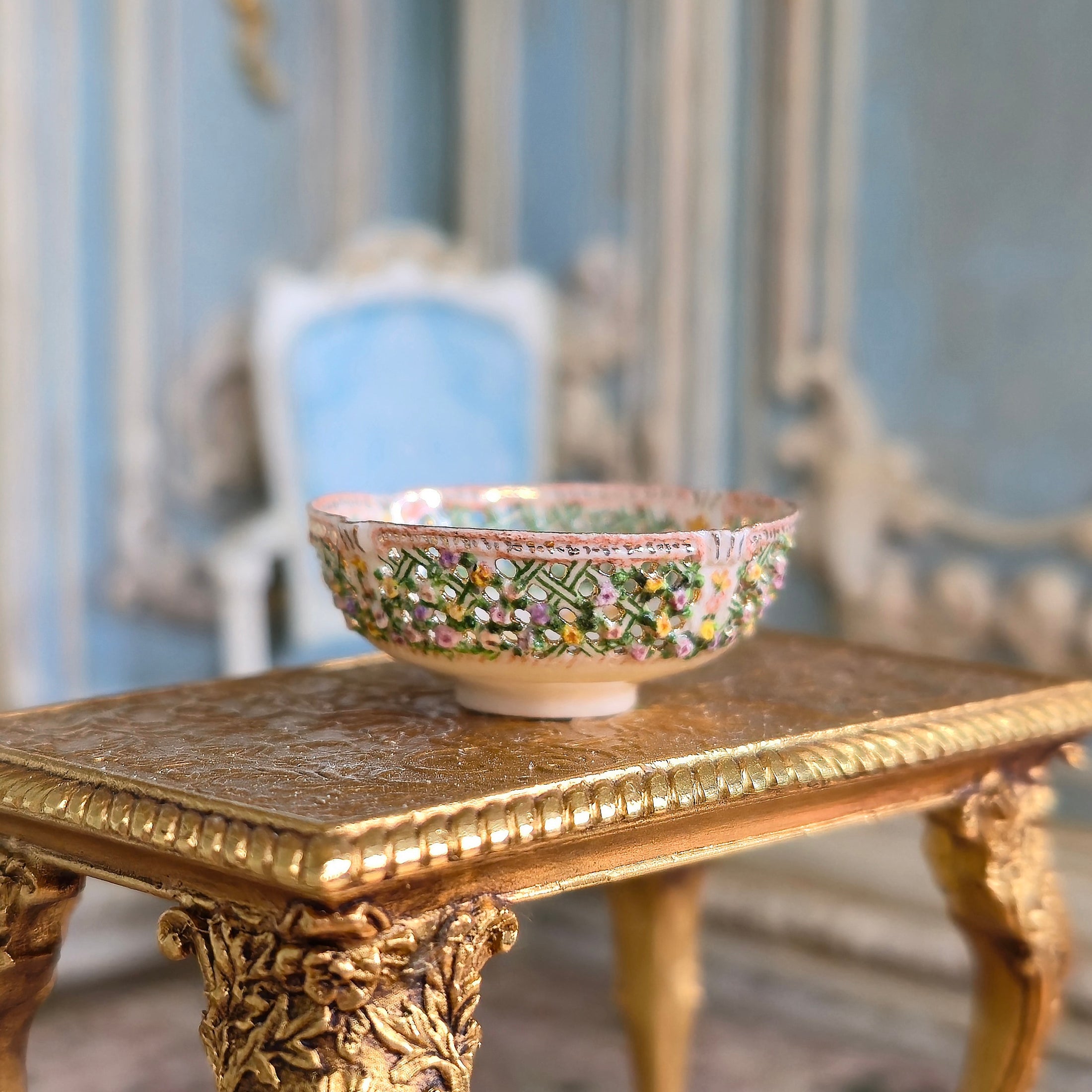 Decorative bowl on a ornate gold table with a blurred classical interior background