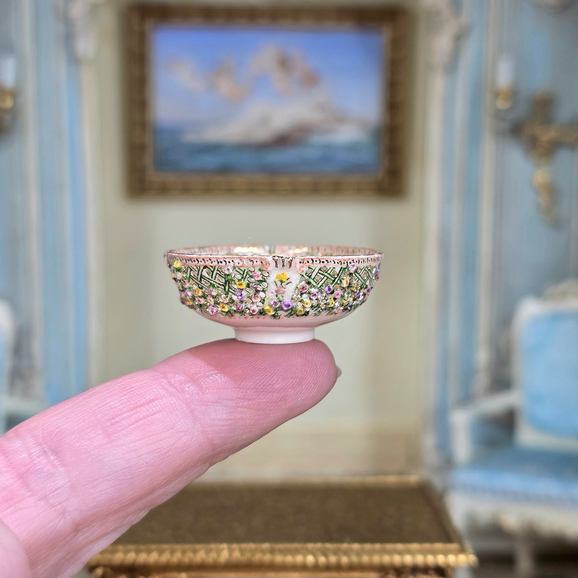 Miniature decorative bowl held on a single finger