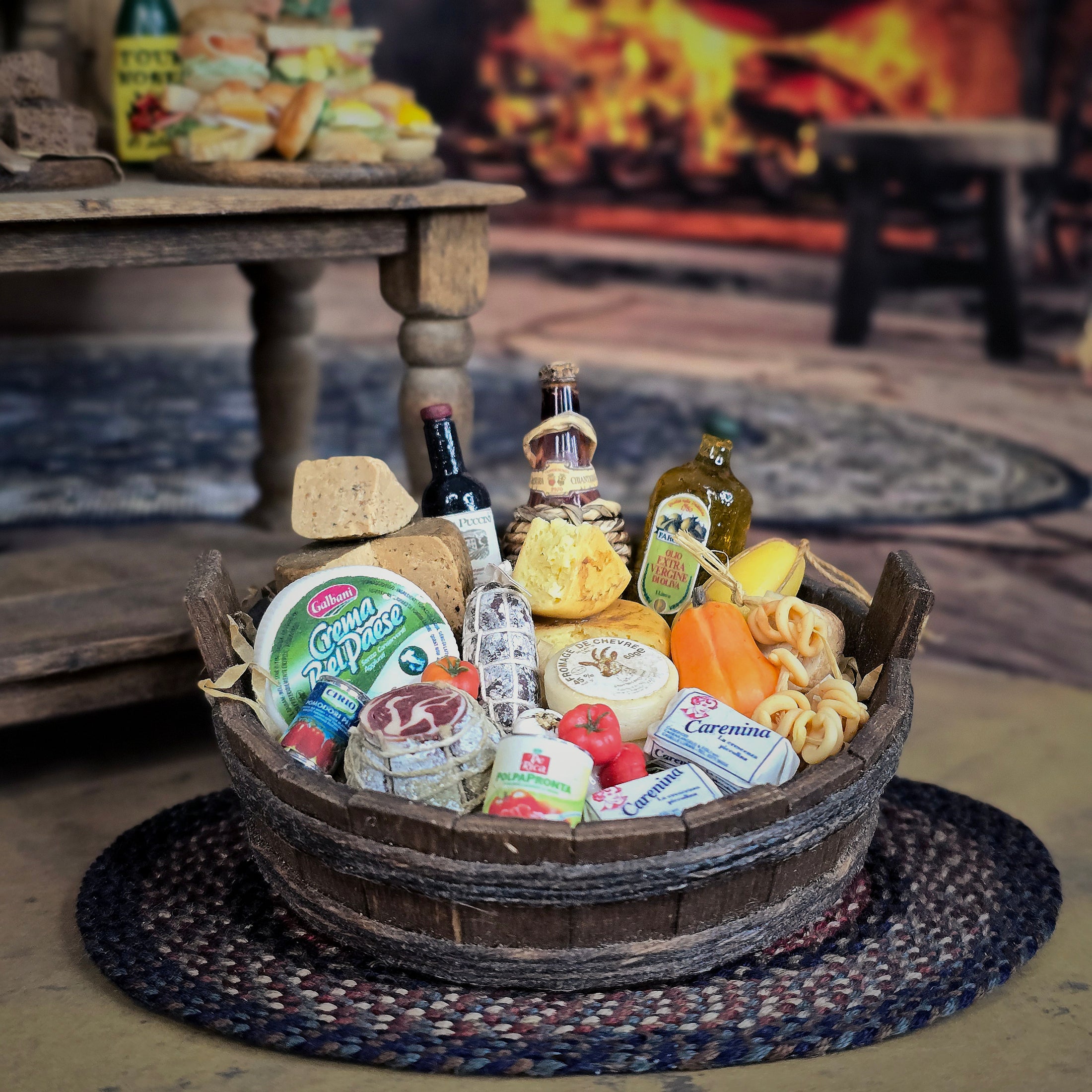Gourmet gift basket with cheeses, meats, and bread on a woven mat.
