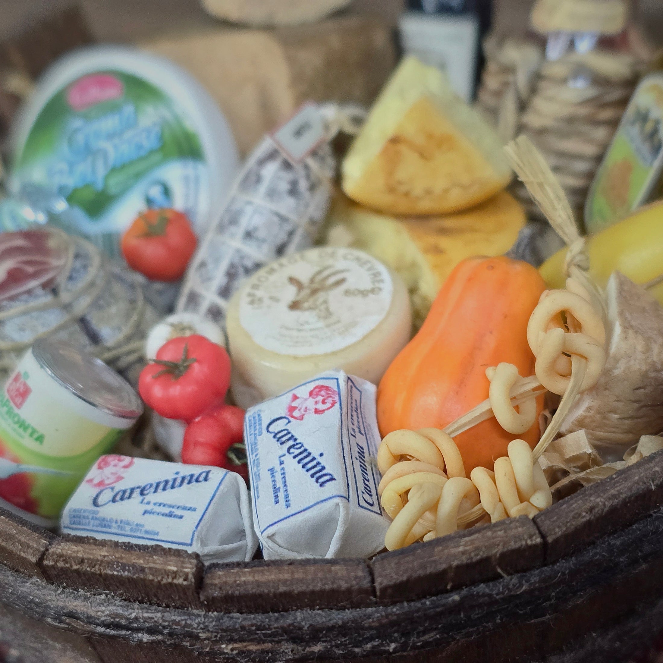 Miniature food items including cheese, tomatoes, and pasta in a wooden basket.