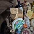 Load image into Gallery viewer, Assorted meats, cheeses, and a bottle of wine in a basket.
