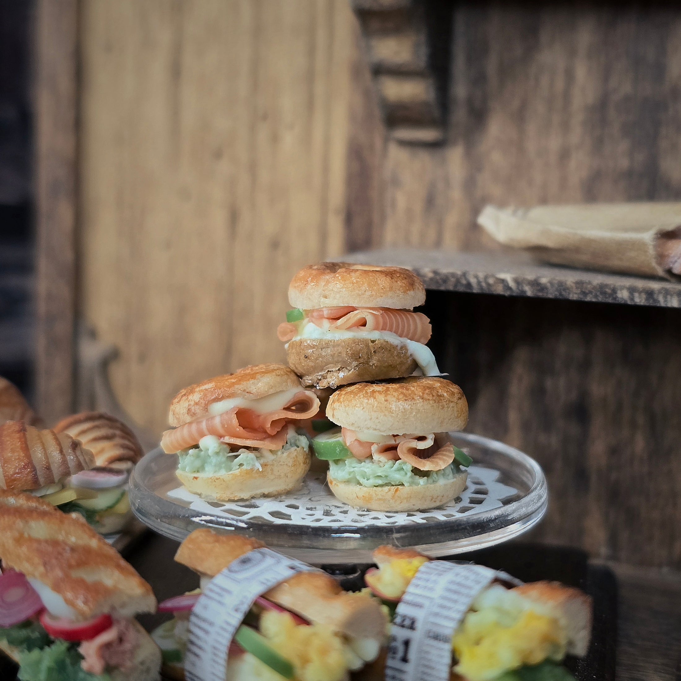 Stack of small sandwiches on a decorative stand with a rustic wooden background