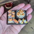 Load image into Gallery viewer, Miniature model of a bakery display with pastries on a hand
