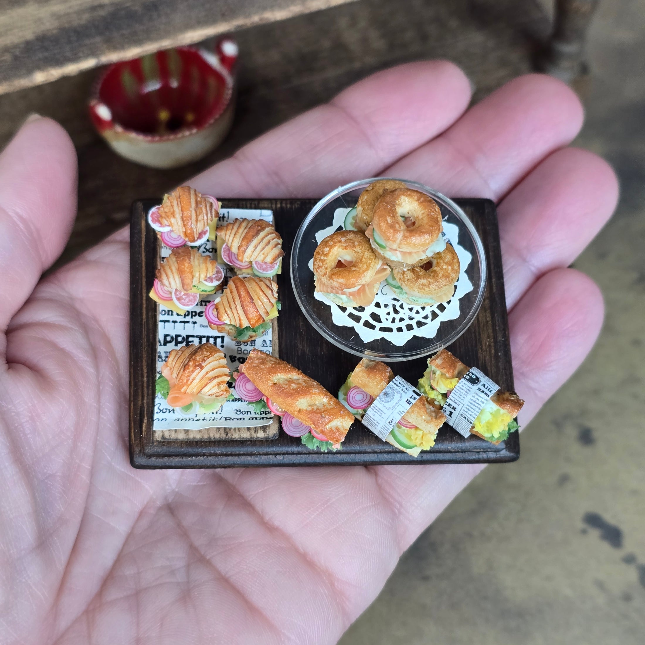 Miniature model of a bakery display with pastries on a hand