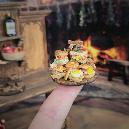 Stack of miniature sandwiches balanced on a finger in front of a cozy fireplace.
