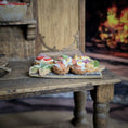 Load image into Gallery viewer, Small food platter with sandwiches on a rustic wooden table in front of a fireplace.
