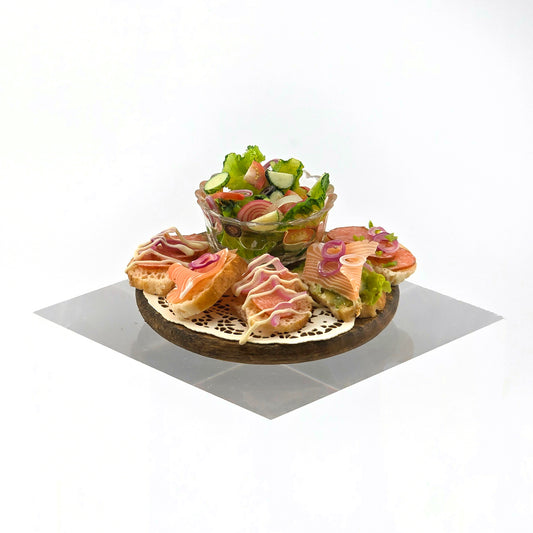 Platter of sandwiches and a bowl of salad on a white background