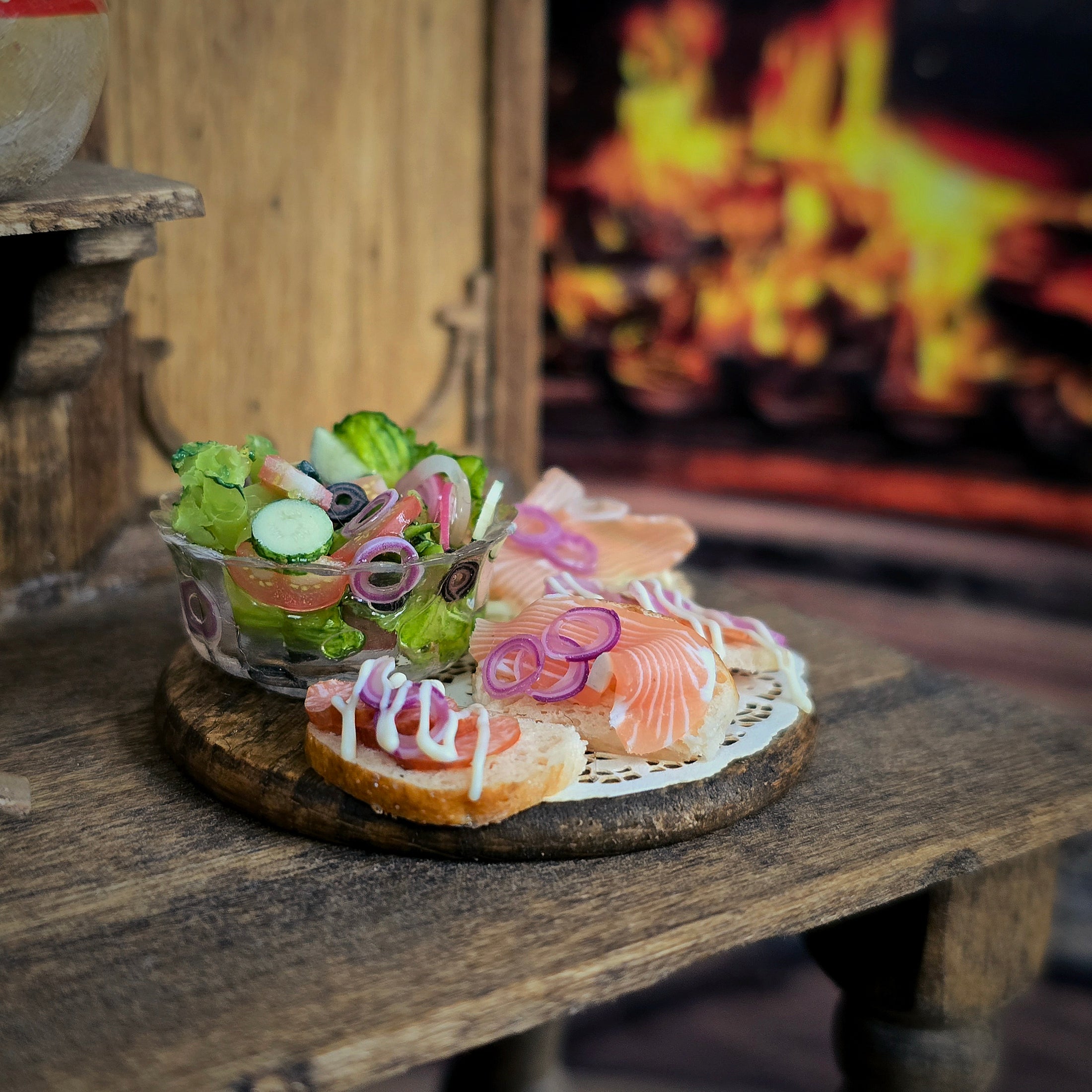 Small dish of salad and sandwiches on a wooden table with a fireplace in the background