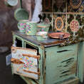 Load image into Gallery viewer, Miniature kitchen scene with a stove and floral cups against a tiled wall.
