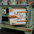 Load image into Gallery viewer, Decorative miniature stove with floral design on the door
