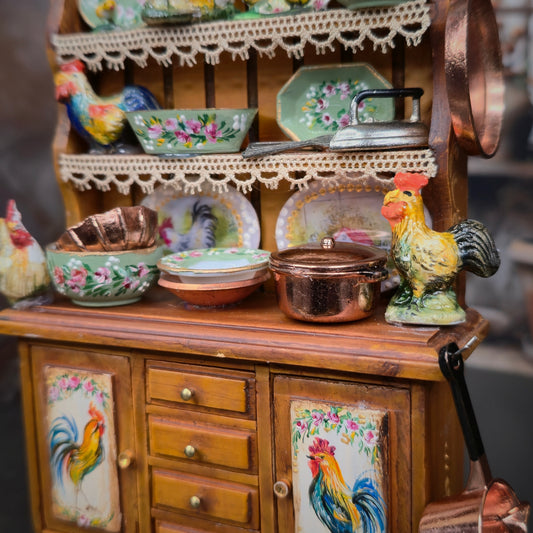 Wooden cabinet with decorative rooster designs and ceramic items on a blurred background