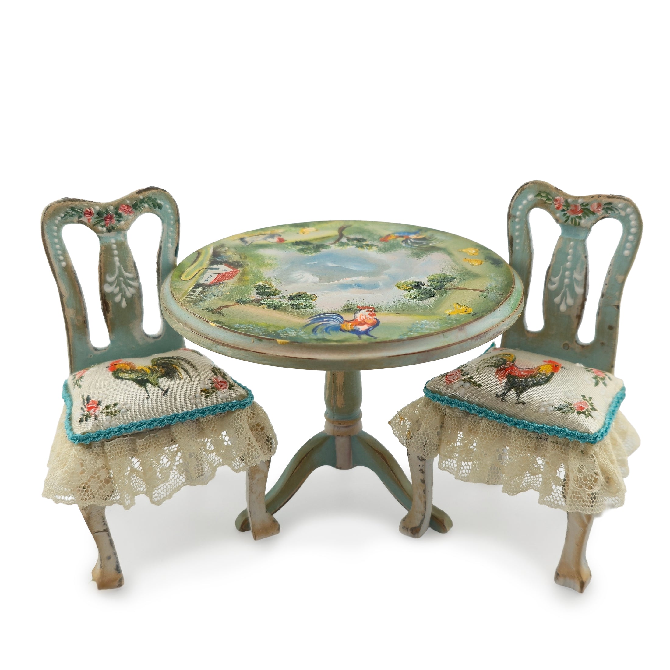 Decorative miniature table and chairs with rooster designs on a white background