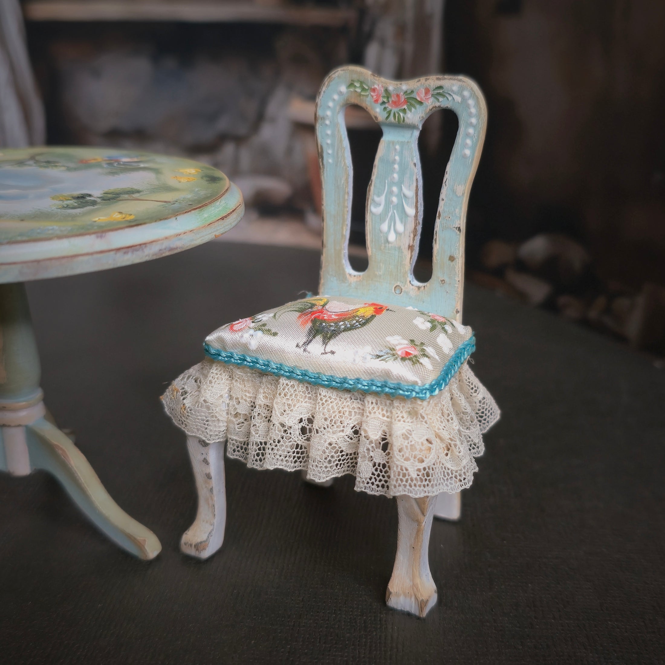 Decorative chair with a cushion featuring a rooster design, set against a blurred background.