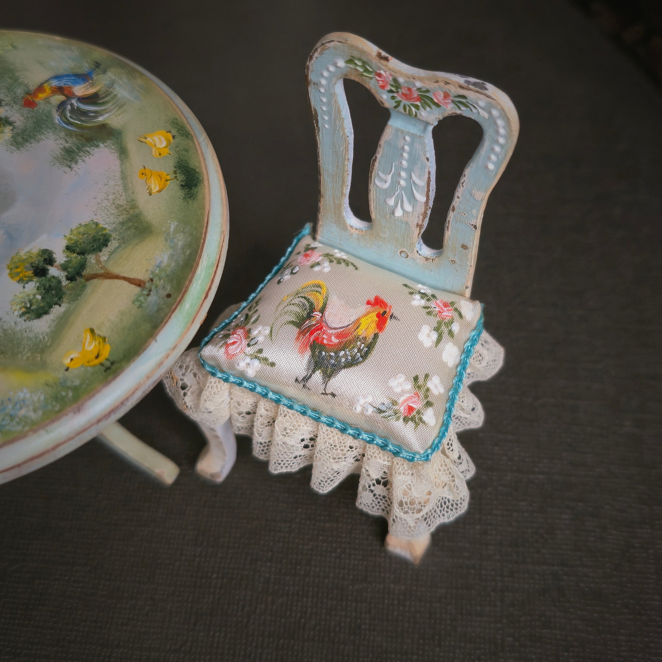 Decorative chair with floral and rooster design on a dark surface