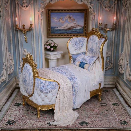 Delicate bed with gold and blue accents in an ornate room.