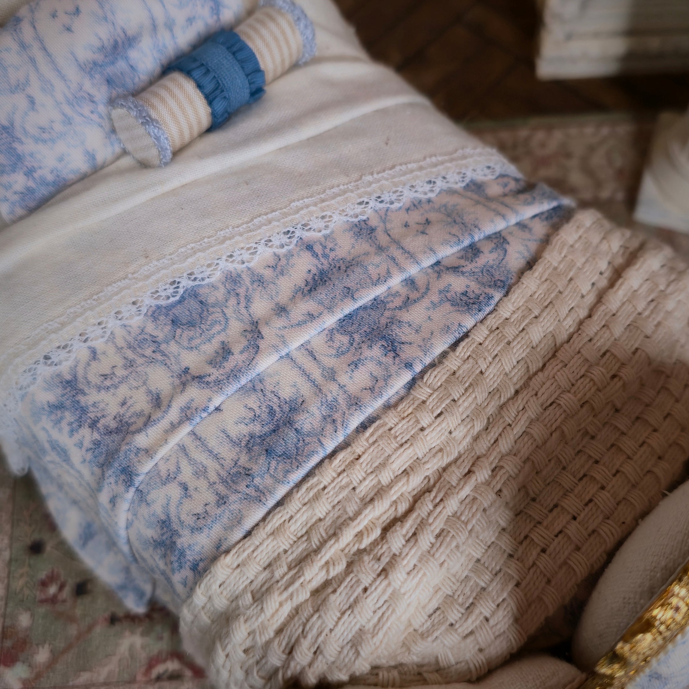 Close-up of a textured blanket with blue toile on a beige background