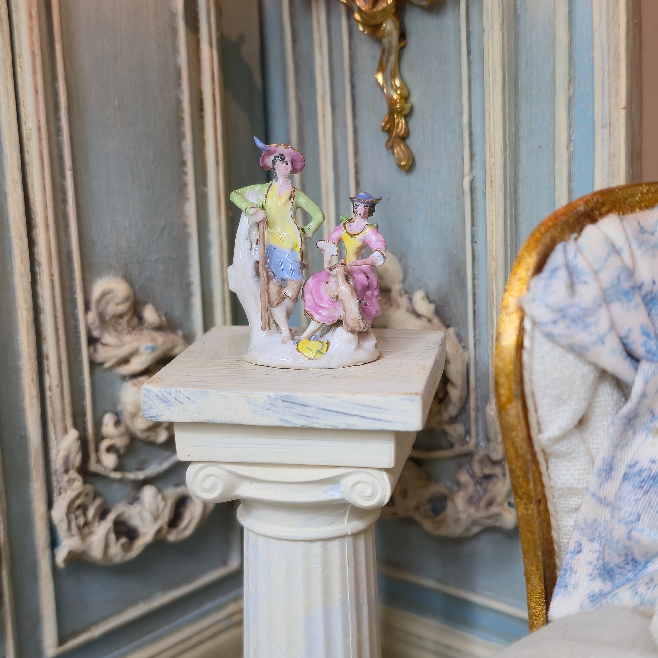 Decorative element with figurines on a ornate chair