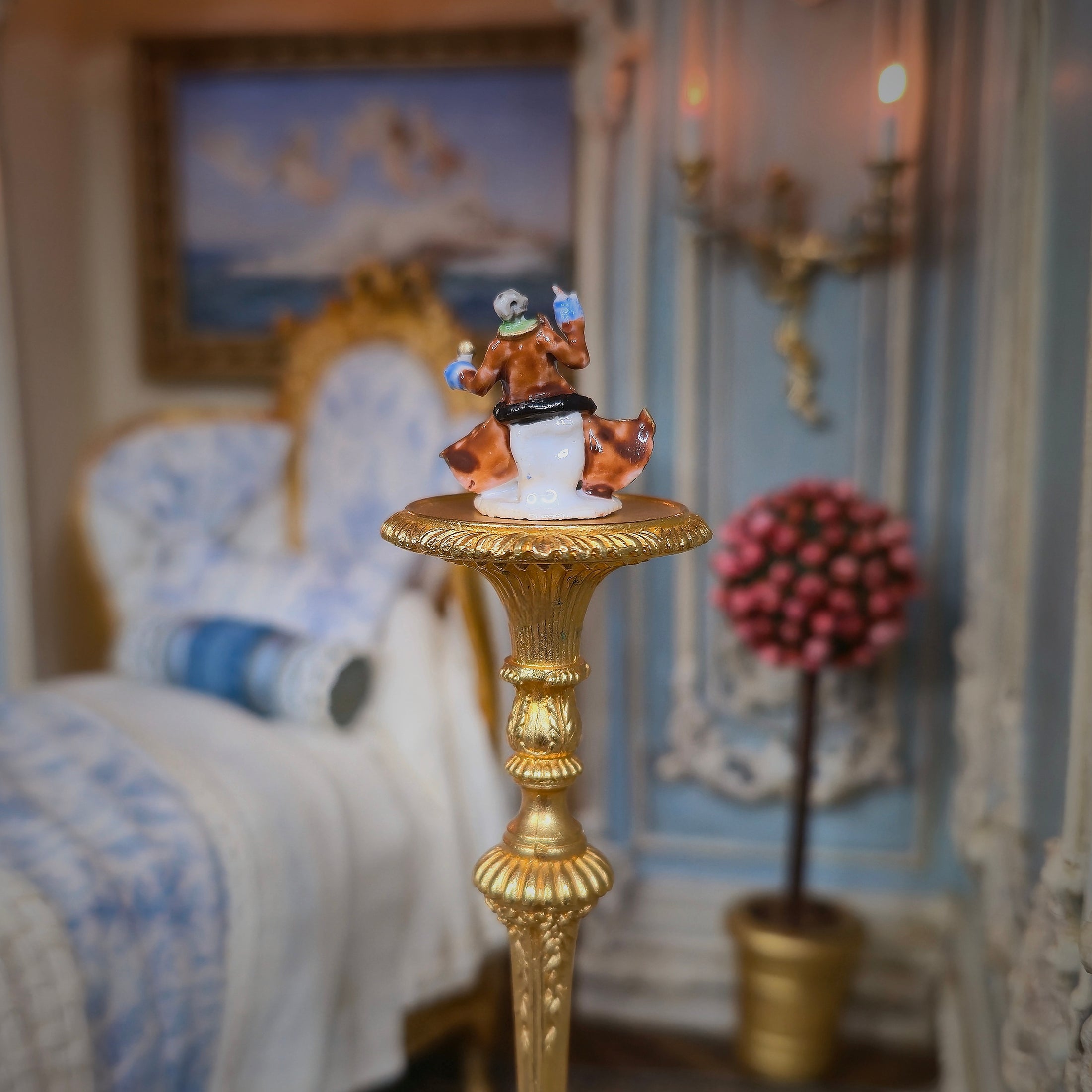Decorative figurine on a gold pedestal in an ornate room setting.