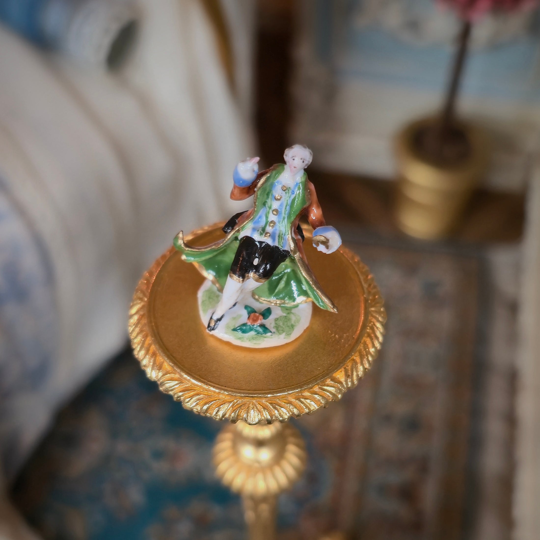 Decorative figurine on a gold stand with a blurred background