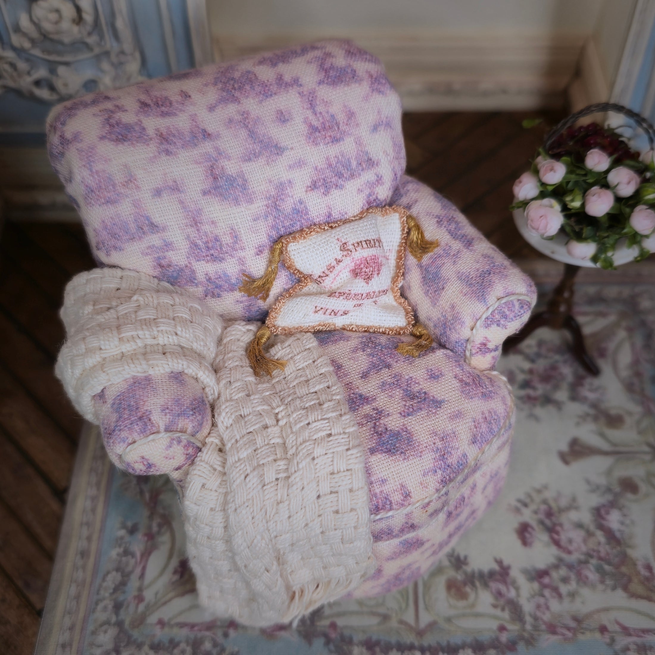 Decorative pillow with floral pattern and text on an upholstered armchair.