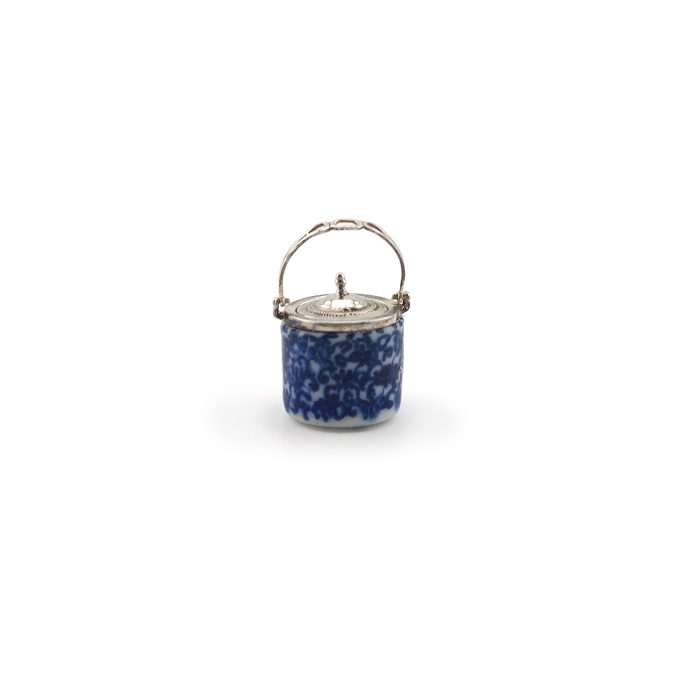 Small blue speckled jar with a silver lid on a white background