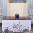 Load image into Gallery viewer, Decorative white chest with intricate carvings on a patterned rug, with a blue and white ceramic item on top.
