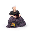 Load image into Gallery viewer, A clay dollhouse doll who is an elderly woman with gray hair, wearing a black top and a dark purple floral skirt, holding tarot cards, set against a plain white background.
