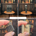 Load image into Gallery viewer, Collage of a miniature book displayed on a stand and held in a hand against a bookshelf background.
