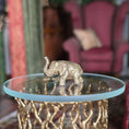 Load image into Gallery viewer, Gold metal elephant figurine on a glass table with a blurred background
