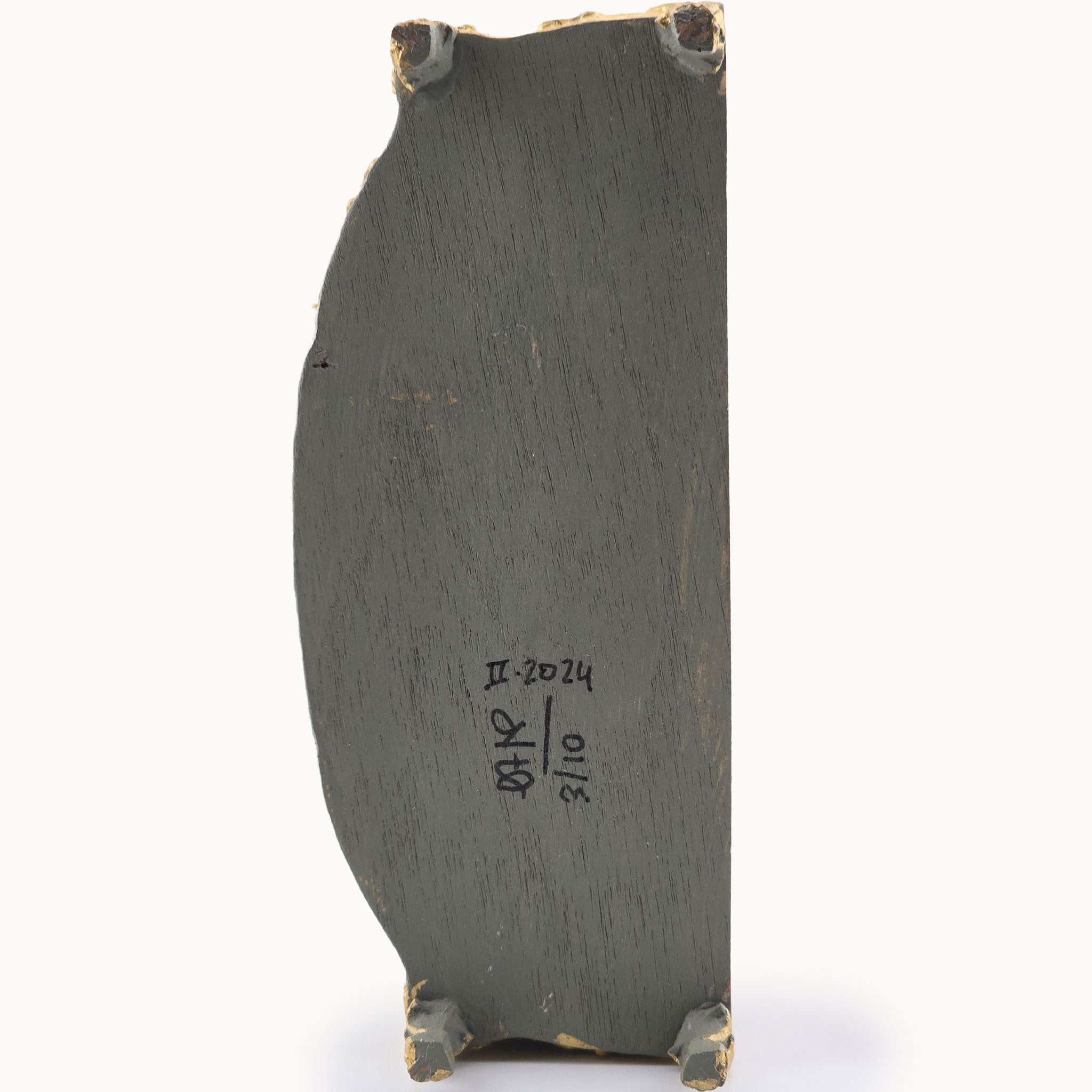 Dark gray painted underside with gold accents on a white background signed by Cristina Noriega Moran