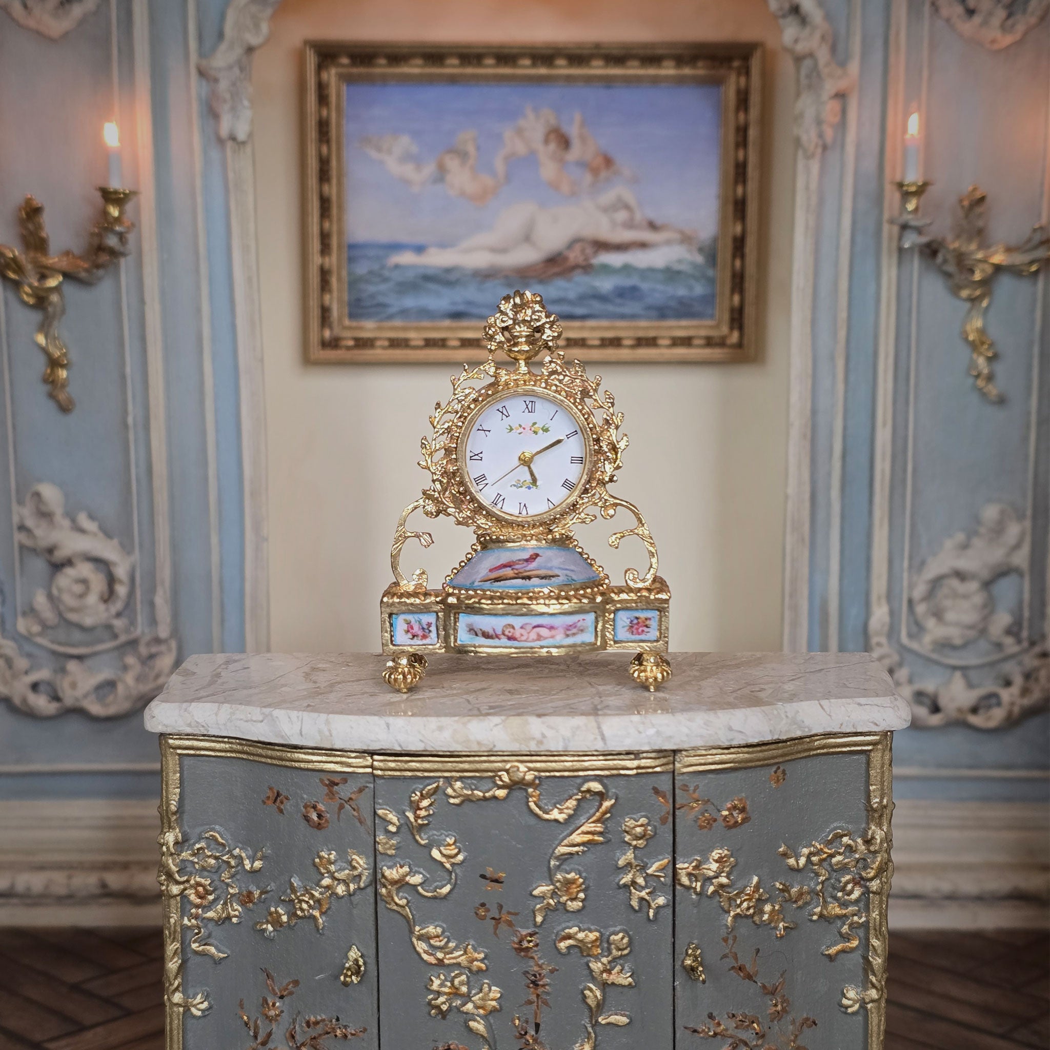 Decorative clock on a ornate cabinet in an elegant room with wall sconces and a painting.