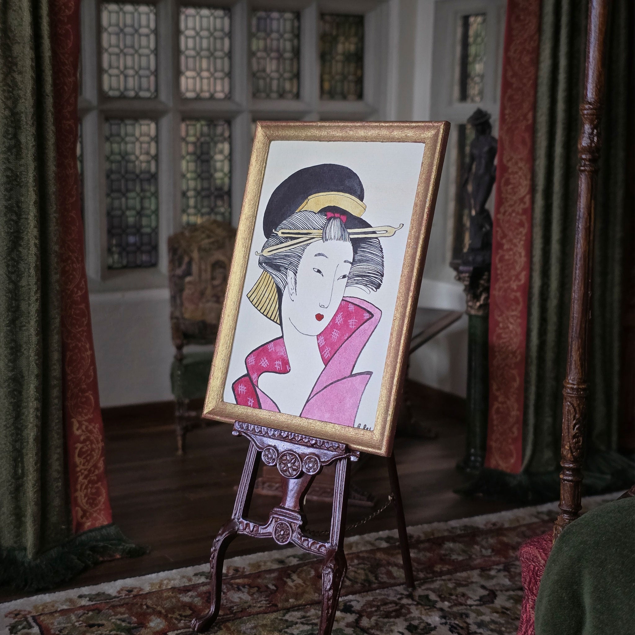 Framed artwork of a traditional Japanese geisha on an easel in a decorative room. Alexandra R.