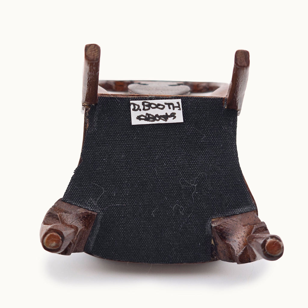 Underside of miniature chair with  'David Booth' label on a white background