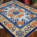 Load image into Gallery viewer, Close-up of a patterned rug with floral designs on a wooden floor.
