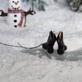Load image into Gallery viewer, Dollhouse miniature Pair of black ice skates on ice with a snowman and snowy background
