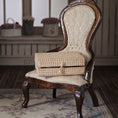 Load image into Gallery viewer, Vintage wooden chair with a wicker trunk on a patterned rug
