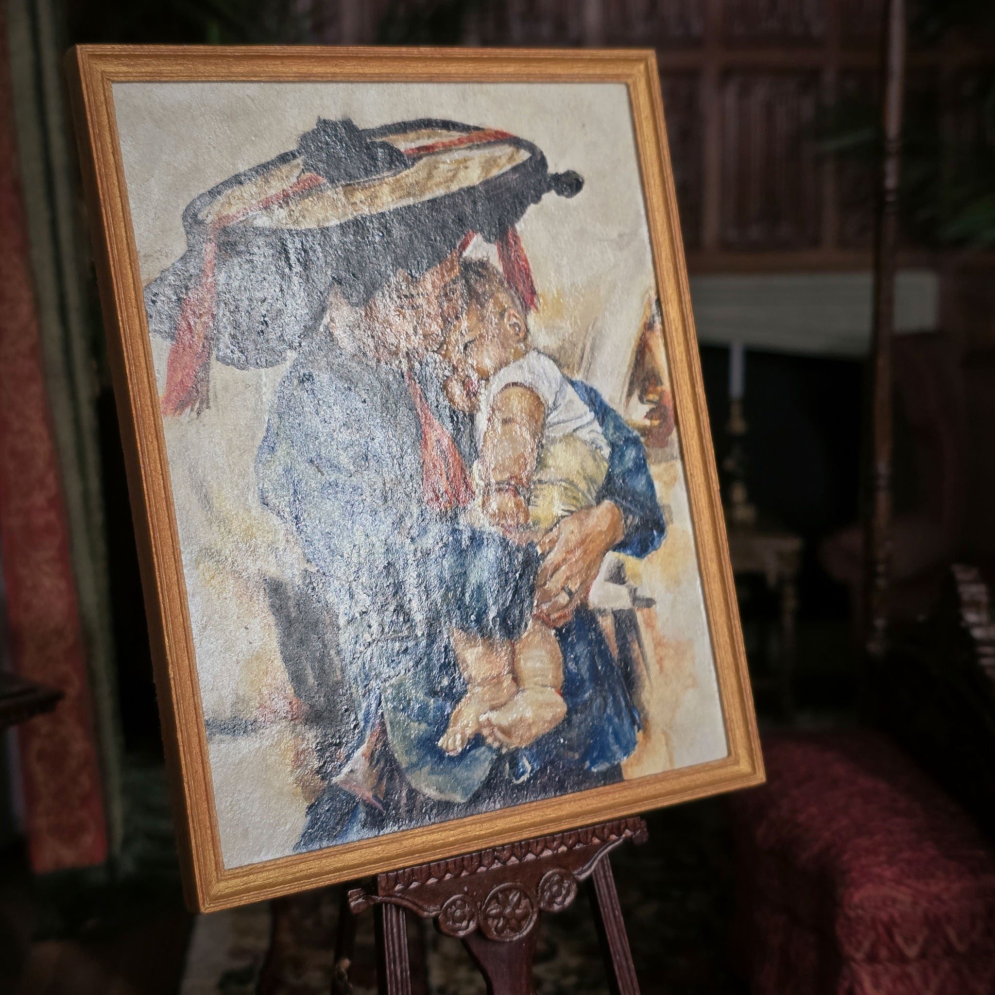 Framed artwork of a woman holding a child on an easel, Deanna Karras