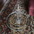 Load image into Gallery viewer, Small Buddha statue on a decorative stand with a patterned fabric background
