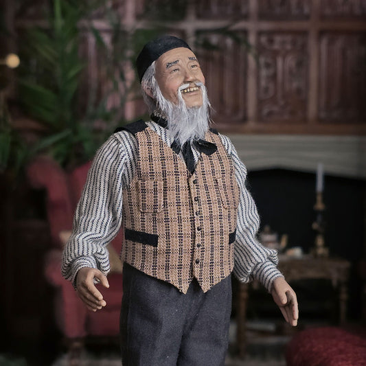 Vintage-style clay dollhouse doll of an elderly man with a long beard in a room setting.